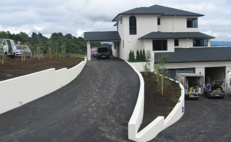 exterior view of newly built big white house with IPMS cars parked